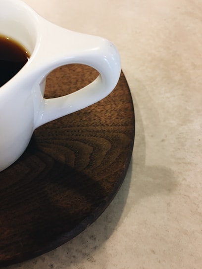 A close-up of a cozy ceramic cup filled with steaming coffee on a wooden table.