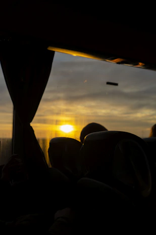 A sunset backdrop with a VTC car parked, passengers chatting happily inside.