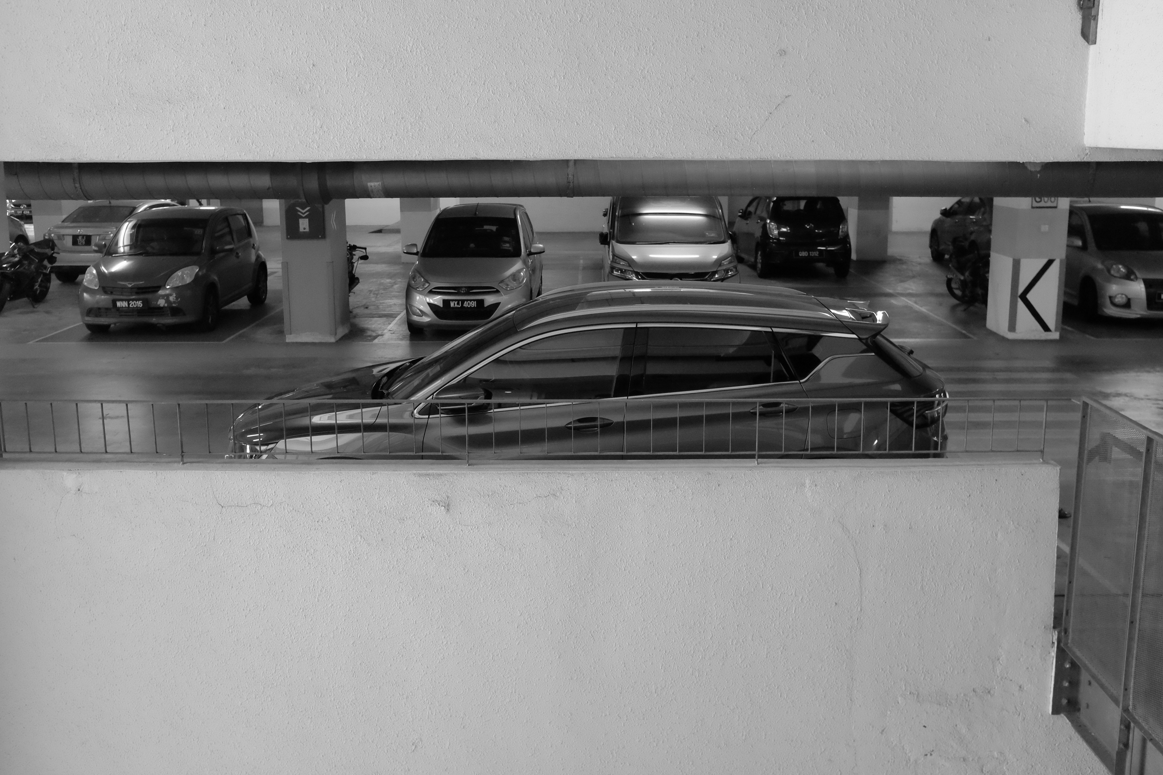 Customer comparing several electric cars parked at a modern dealership showroom