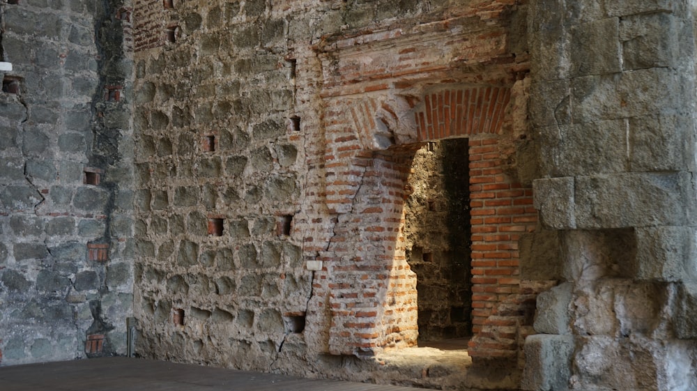 a brick wall with a small window in it