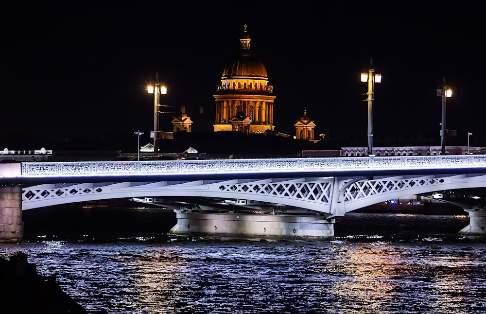 a bridge over a body of water with a building in the background