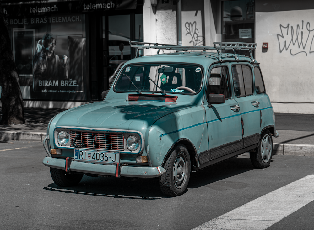 una piccola auto blu parcheggiata sul ciglio della strada