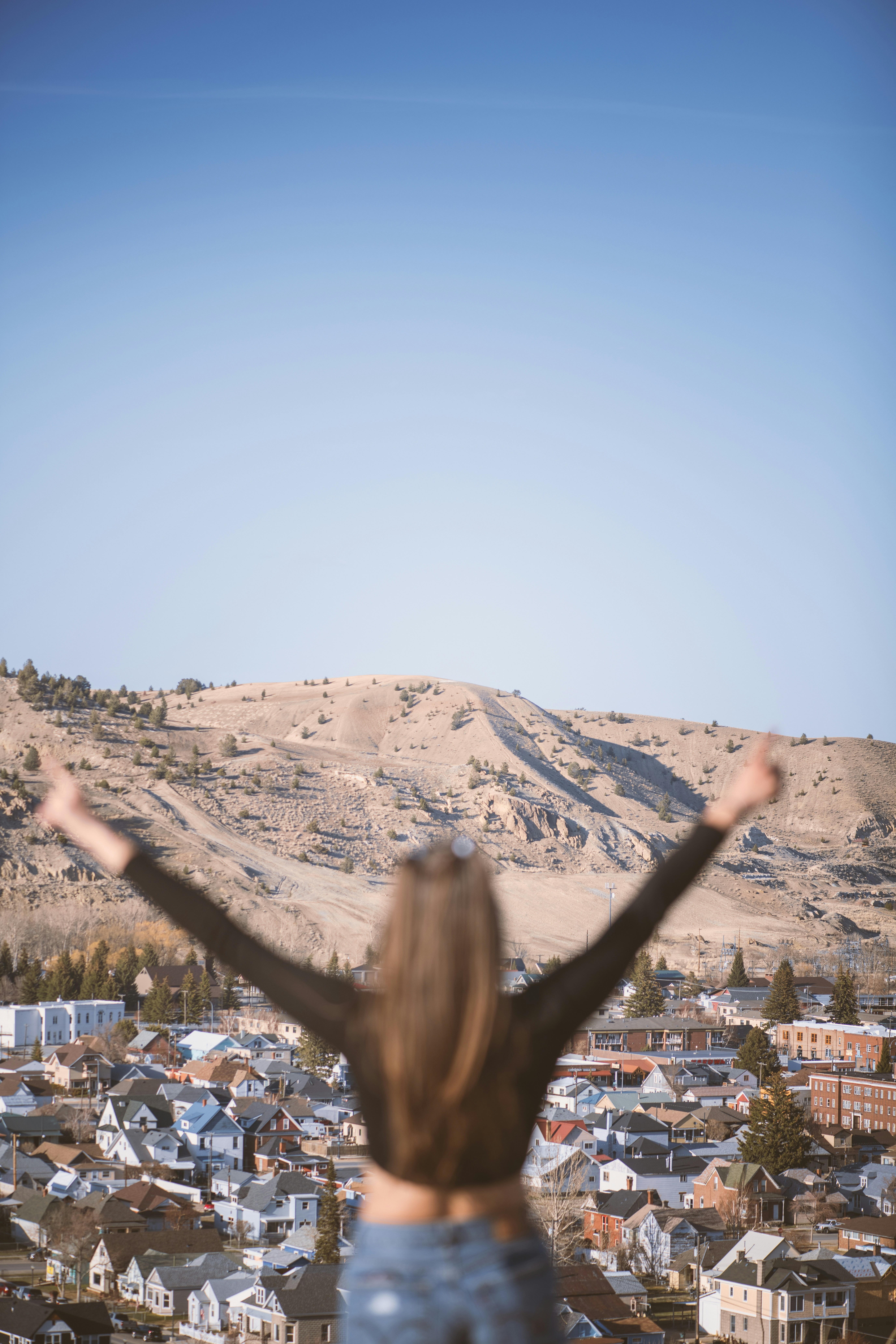 A woman standing on top of a hill with her arms outstretched photo ...