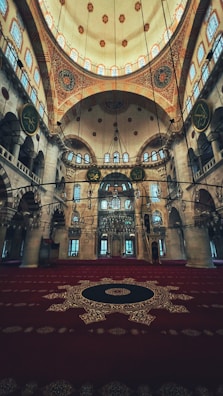 Colorful prayer rugs laid out under the sacred dome inside the mosque.