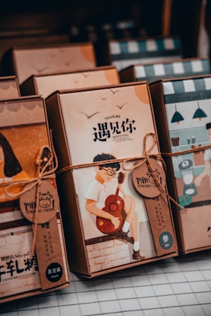 Several packaged goods, possibly books or boxes of stationery, are neatly arranged. Each package is wrapped with a string, and one prominently features an illustration of a person playing the guitar. The text on the package includes both English and Chinese characters.