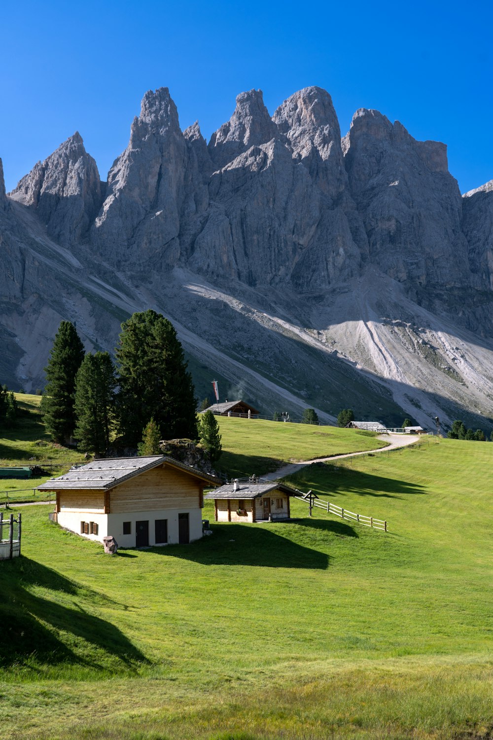 a house in a field with mountains in the background