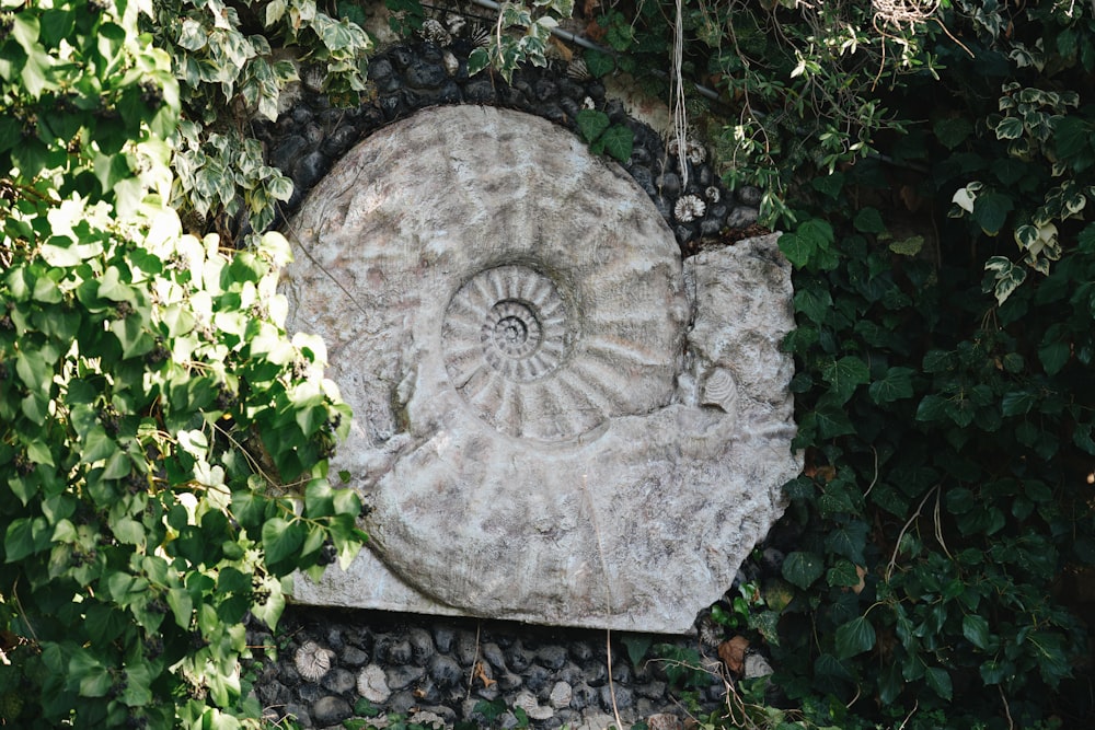 a stone sculpture surrounded by greenery in a garden