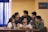 A family gathered around a table, engaging in a discussion with smiles.