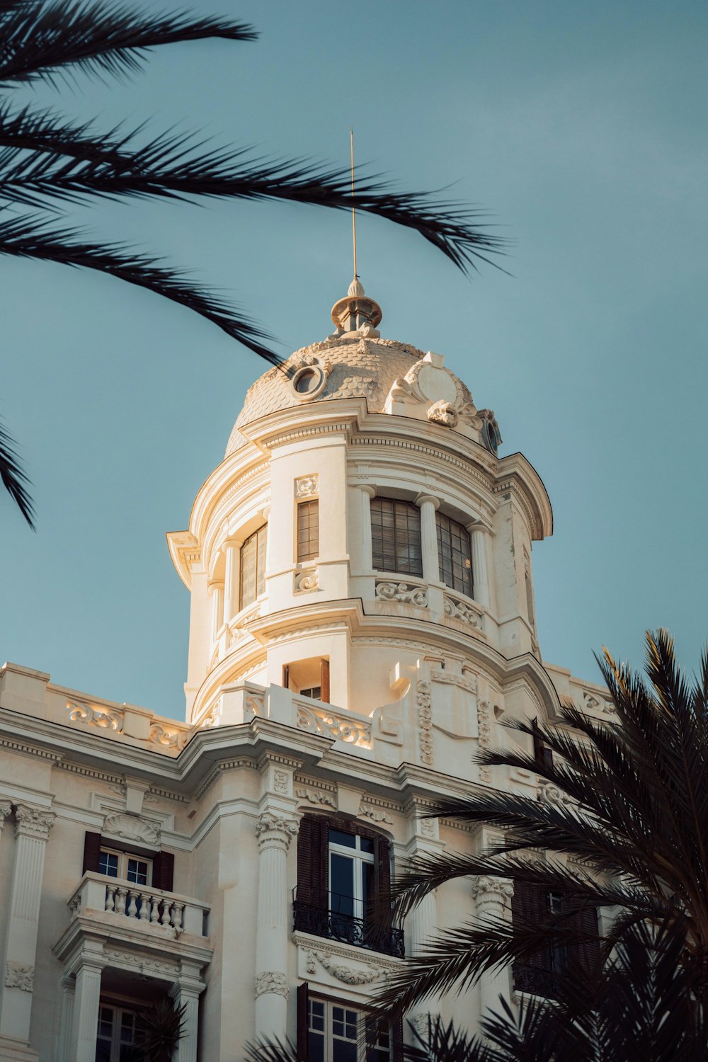 a tall white building with a clock on top