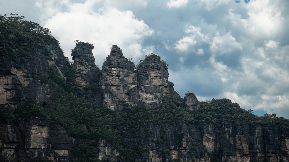 a group of rocks sitting on top of a lush green hillside