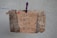 A handmade sign with the message 'Creativity is better left unconfined' is attached to a weathered, textured background using a purple clothespin on a blue and white rope. The sign blends an artistic mix of handwritten styles in a combination of black and some colorful accents.