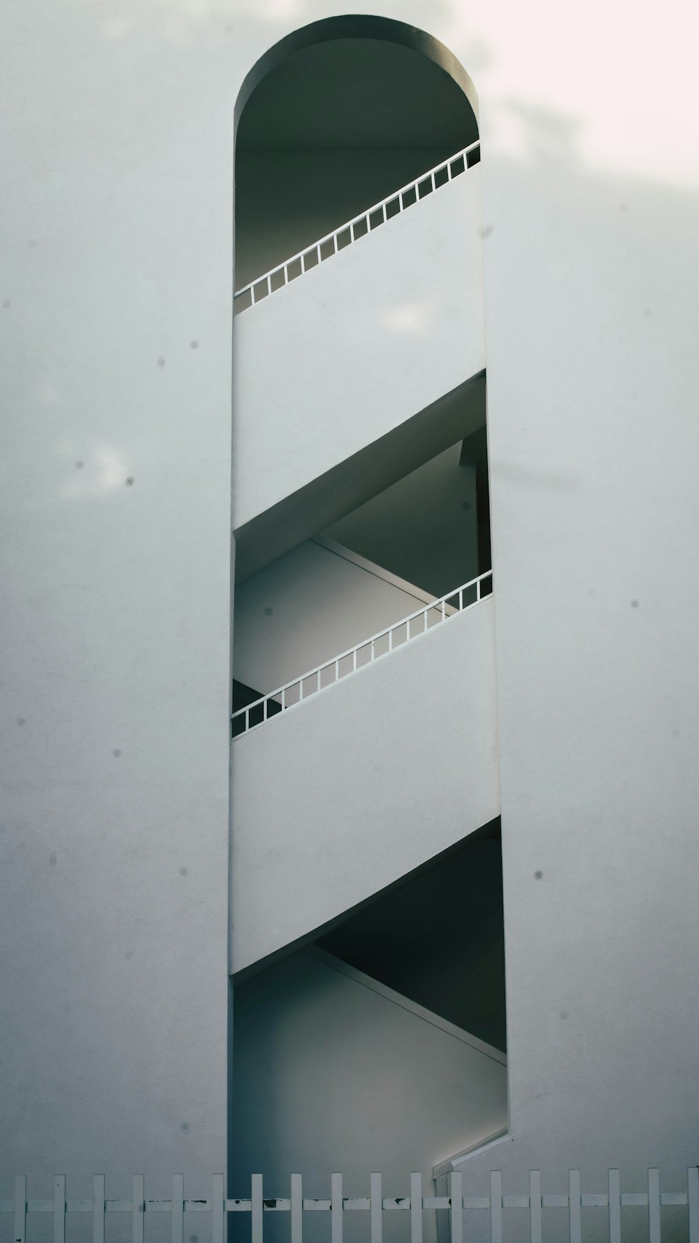 a tall white building with a white fence around it