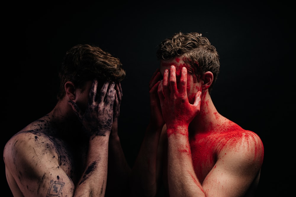 a couple of men covered in blood covering their faces