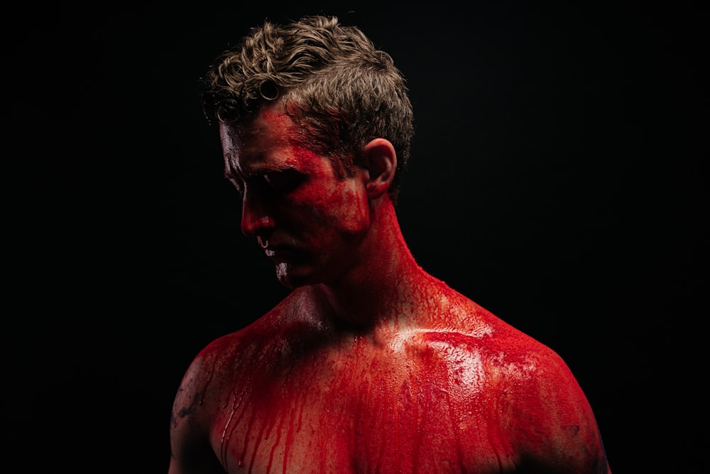 a man with red paint on his face and chest