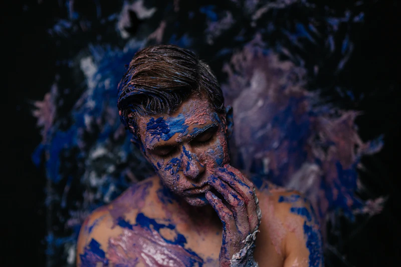 bold LGBTQ man covered in blue and purple paint