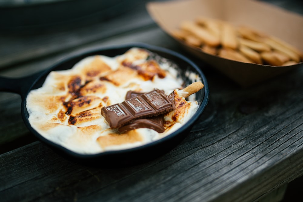 a pan filled with food next to a bowl of crackers