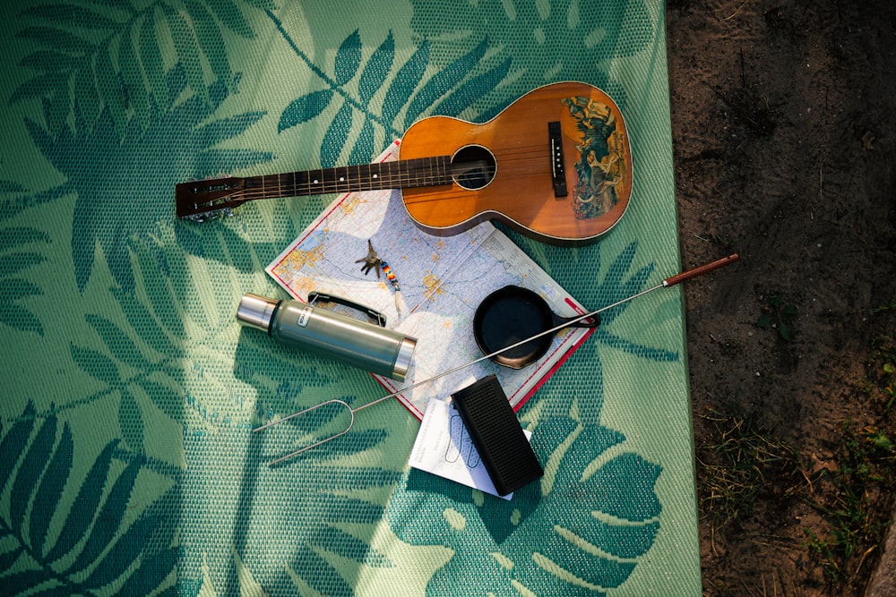 a guitar and other items are laying on a blanket