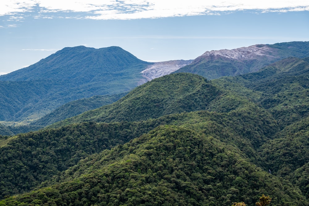 a view of a mountain range with trees and mountains in the background