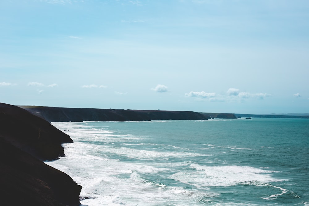 a large body of water sitting next to a cliff