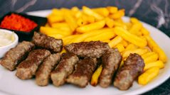 a white plate topped with meat and french fries