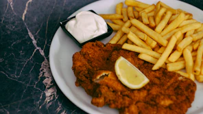 a white plate topped with fried chicken and french fries
