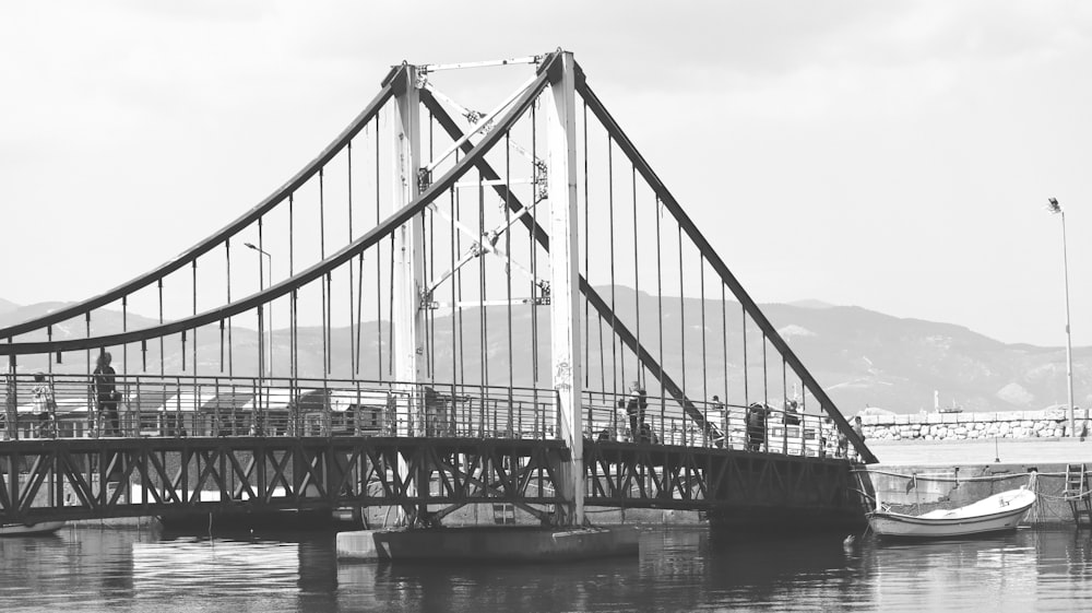 a black and white photo of a bridge over water