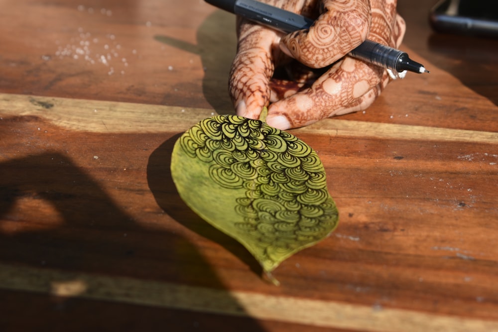 Un hendily está haciendo algo en un pedazo de madera