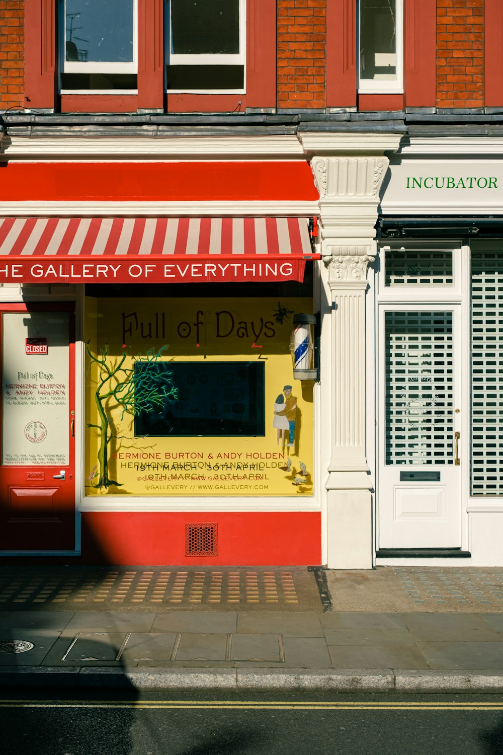 a red and white building with a red and white awning