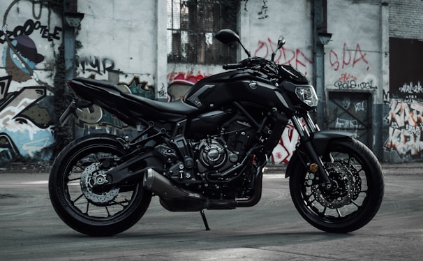A close-up of a sleek motorcycle parked against a graffiti-covered wall.