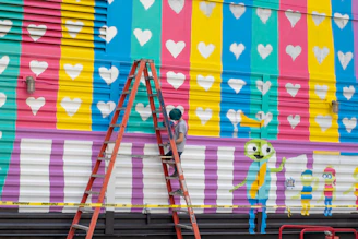 Young Cameroonian artist passionately painting a vibrant mural at a community event.