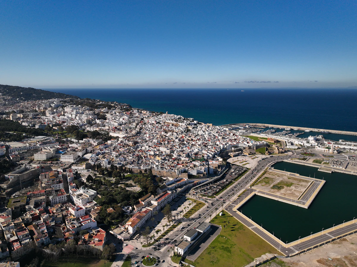 Vue aérienne de la médina blanche de Tanger sous un ciel ensoleillé, ambiance port méditerranéen