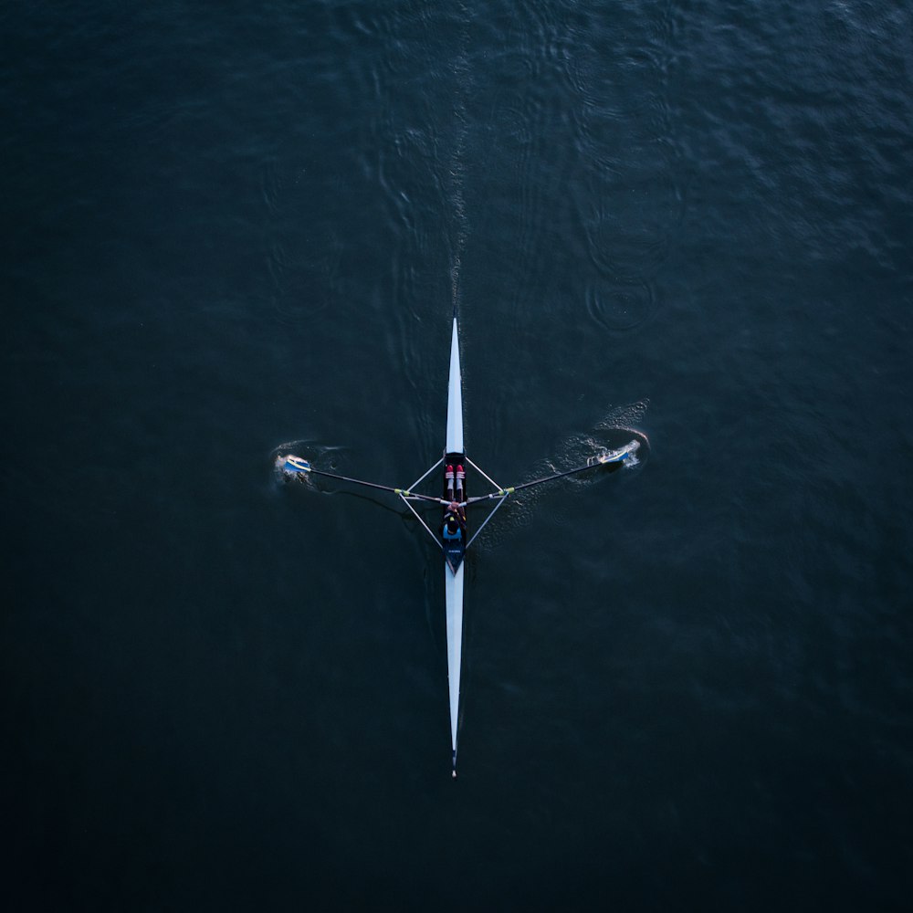 two people rowing a boat on a large body of water