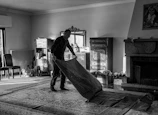 Janos carefully cleaning a large oriental rug in a bright, modern home.