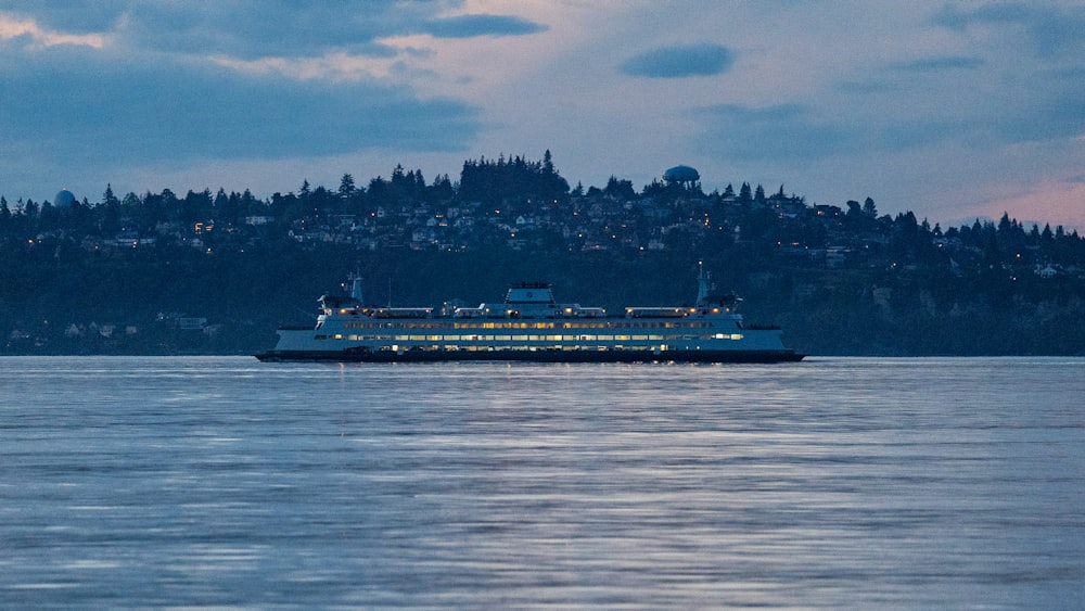 a cruise ship in a body of water with a city in the background