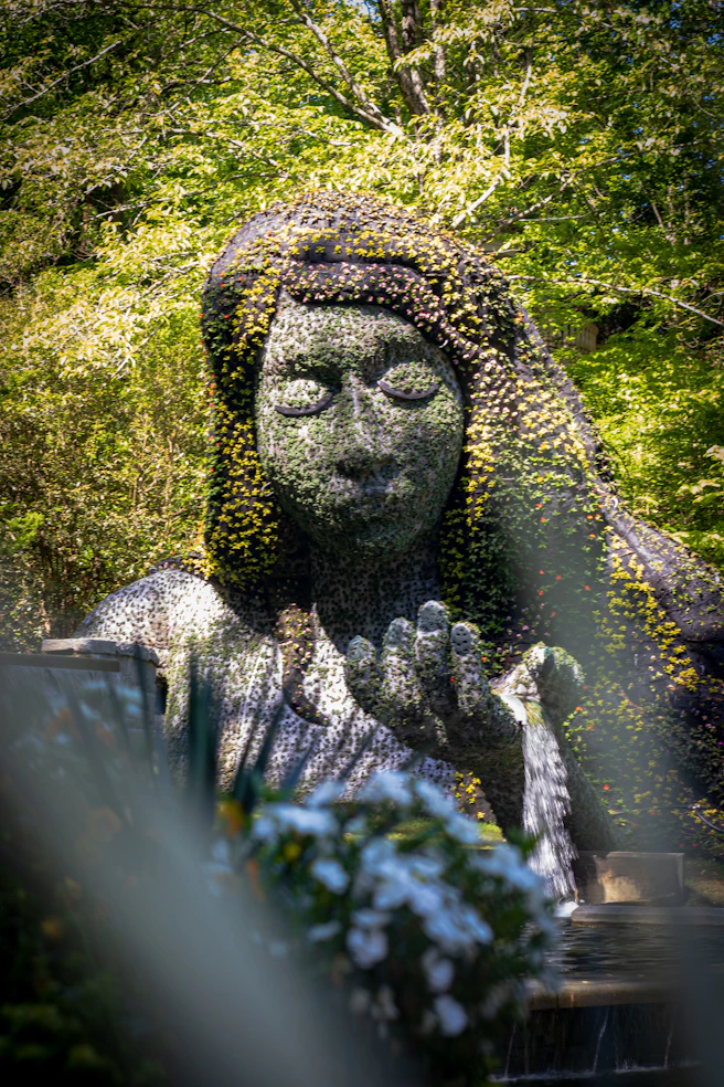 a statue of a woman covered in flowers