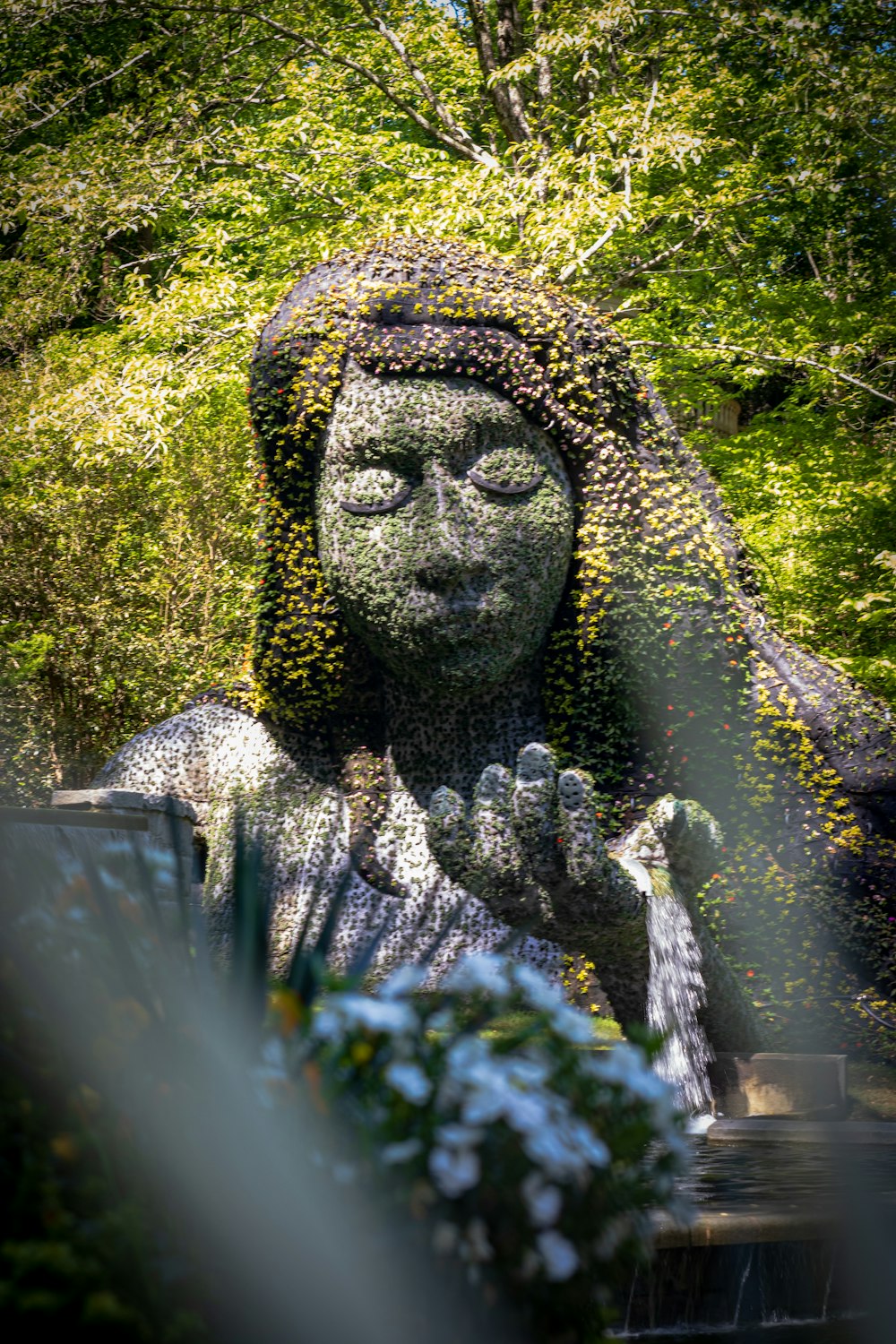 Una estatua de una mujer cubierta de flores