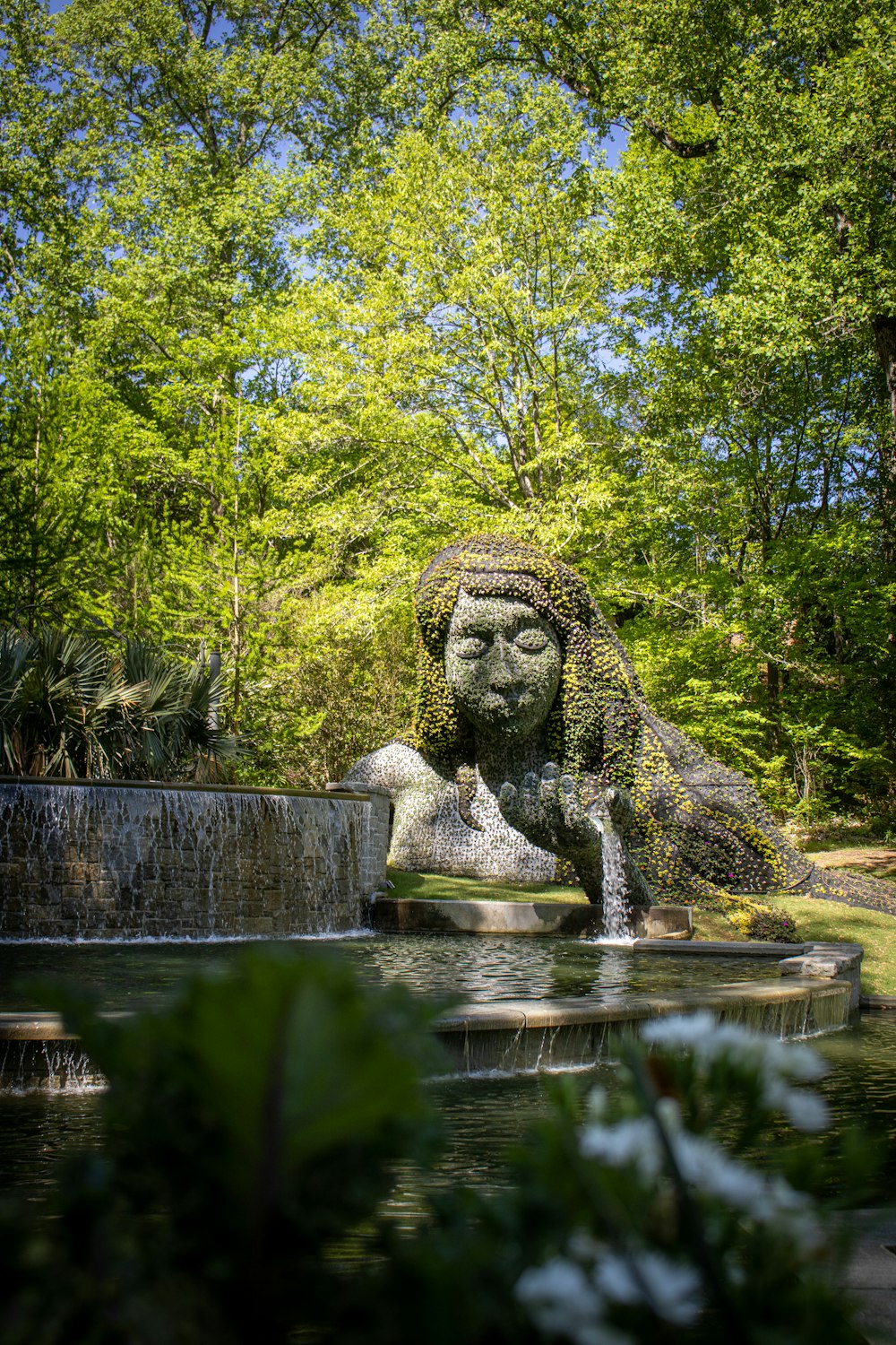 una fuente de agua con una estatua de una mujer en el medio de ella