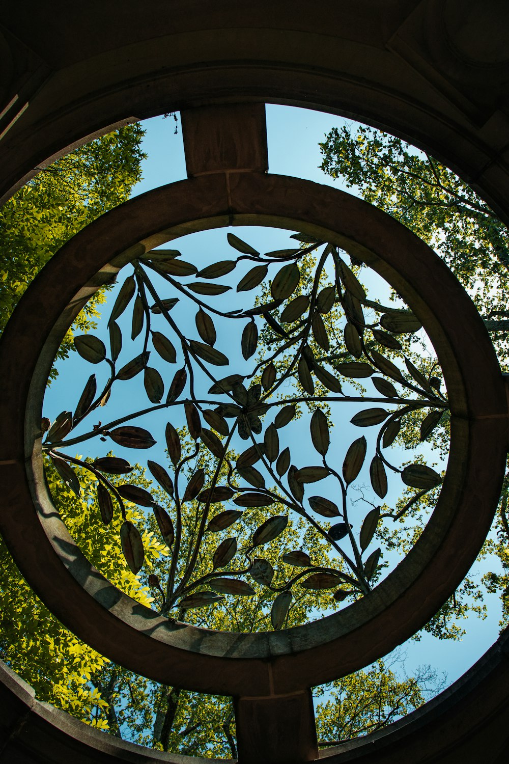 a circular window with a view of trees through it