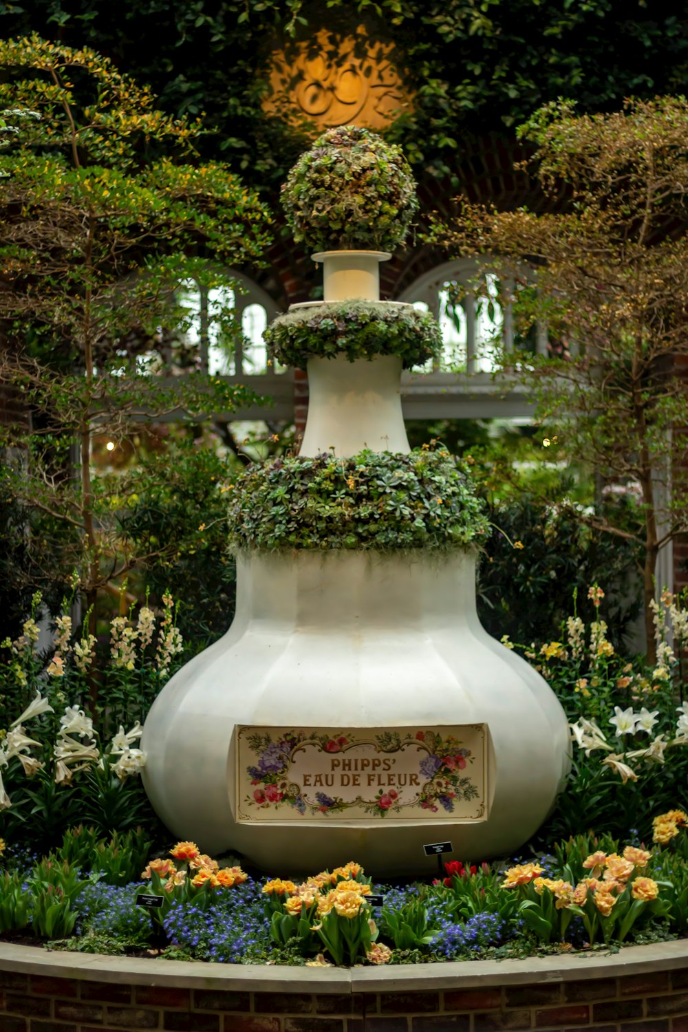 Un jarrón blanco con un letrero rodeado de flores