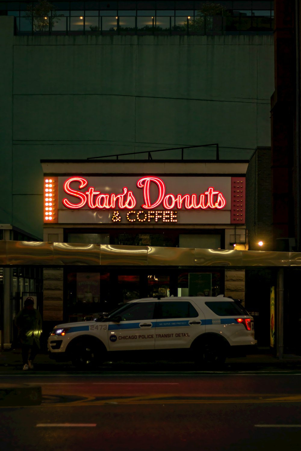 a police car parked in front of a donut shop