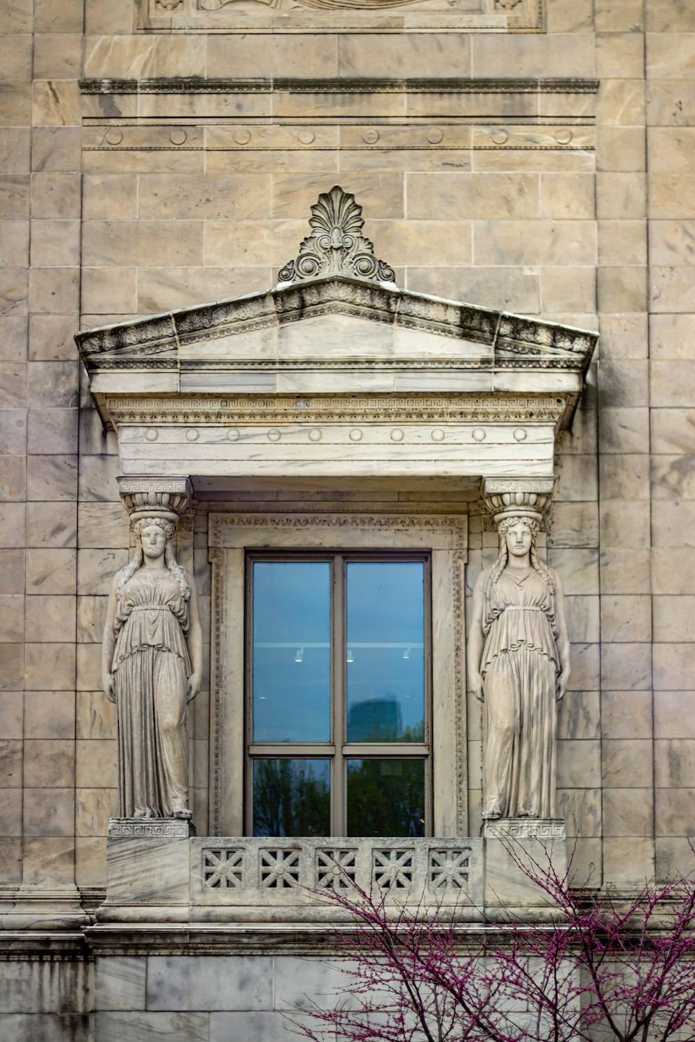 une fenêtre avec des statues sur le côté
