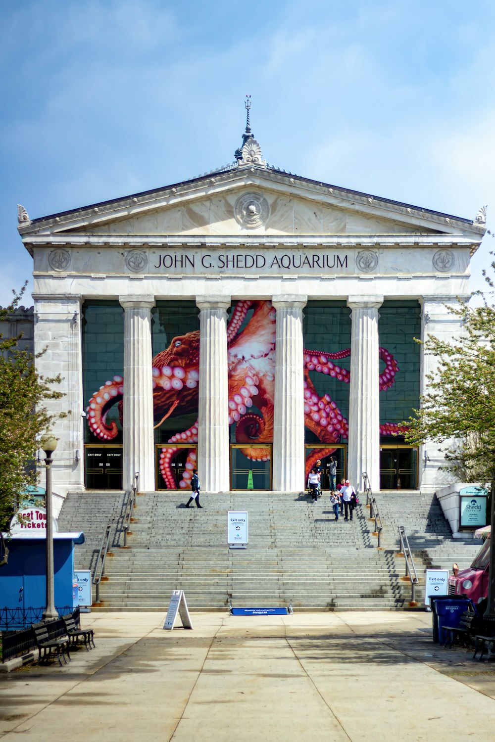 un gran edificio con columnas y un mural en el lateral