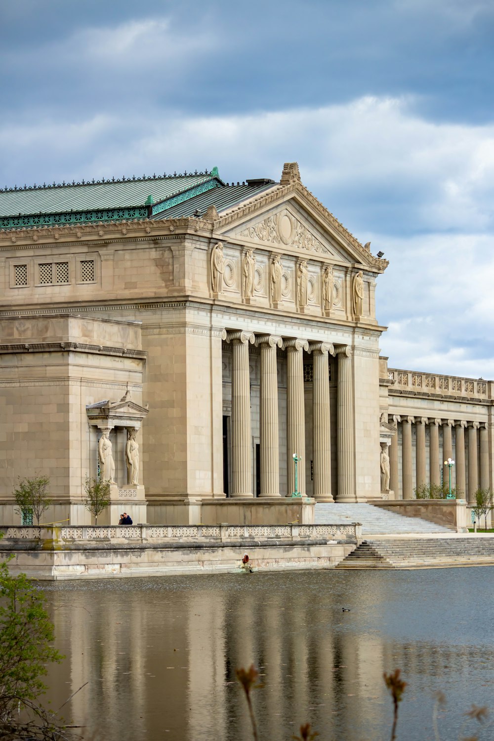 a large building with columns and a green roof