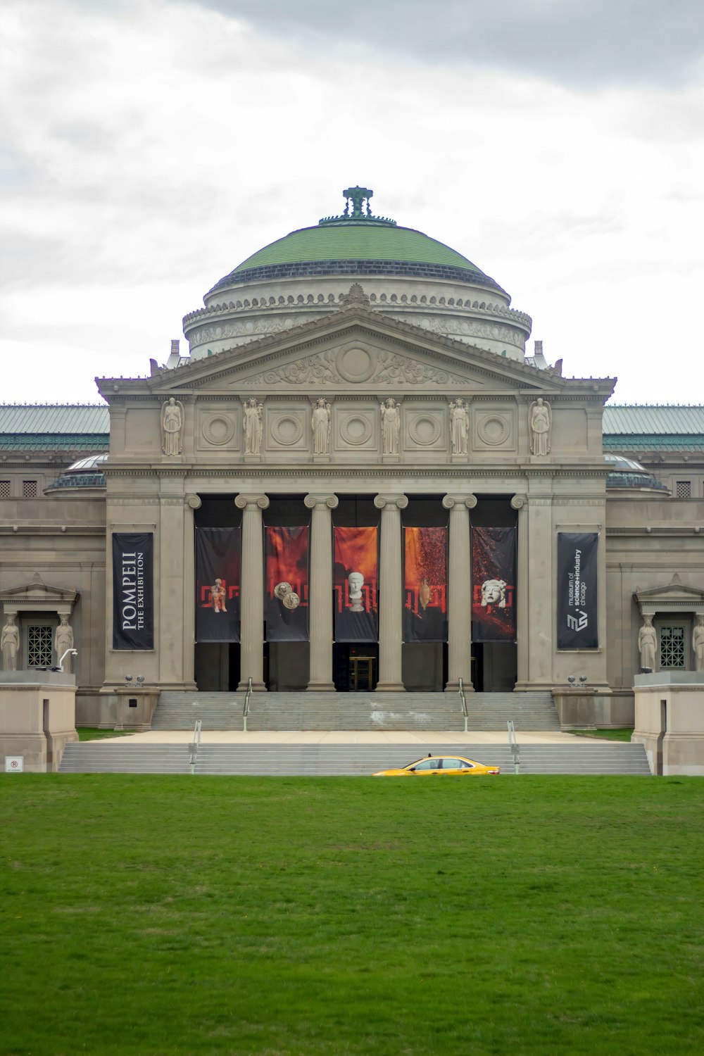 a large building with columns and a green roof