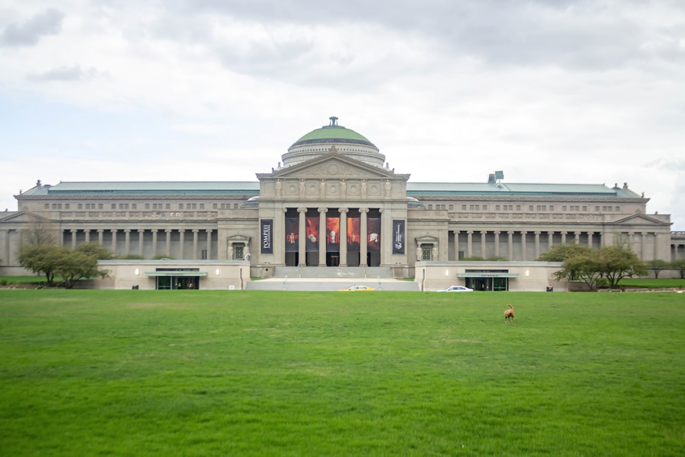 a large building with a green lawn in front of it