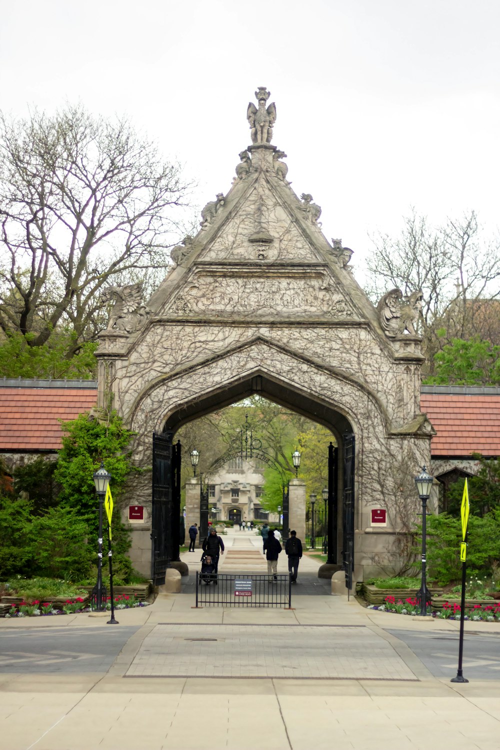 a group of people walking under a stone archway