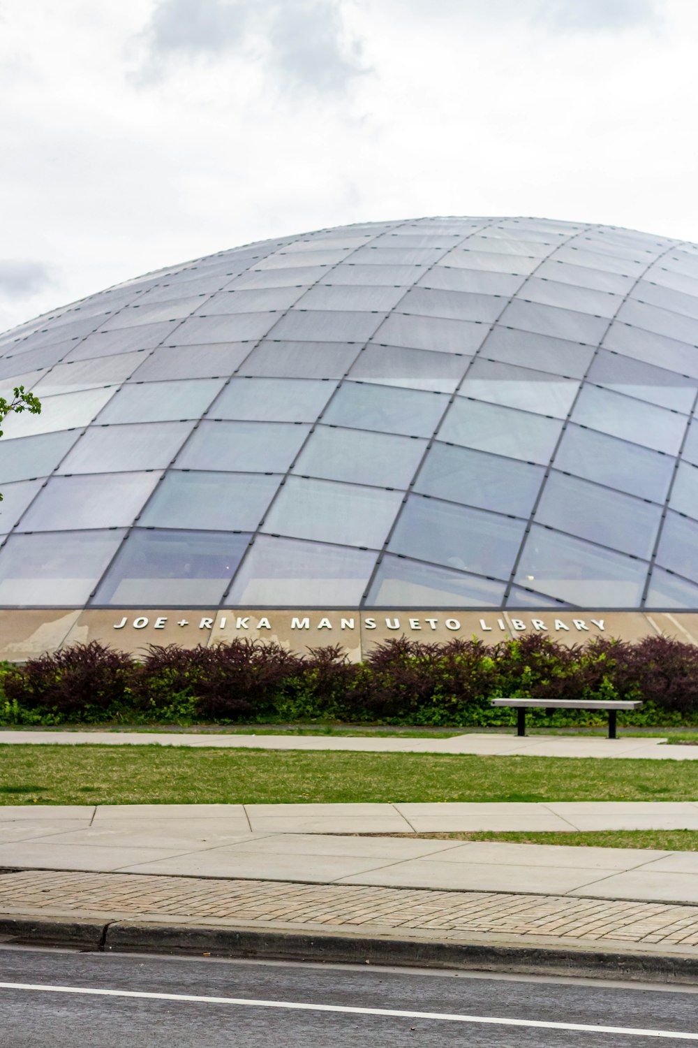 a large glass building sitting on the side of a road