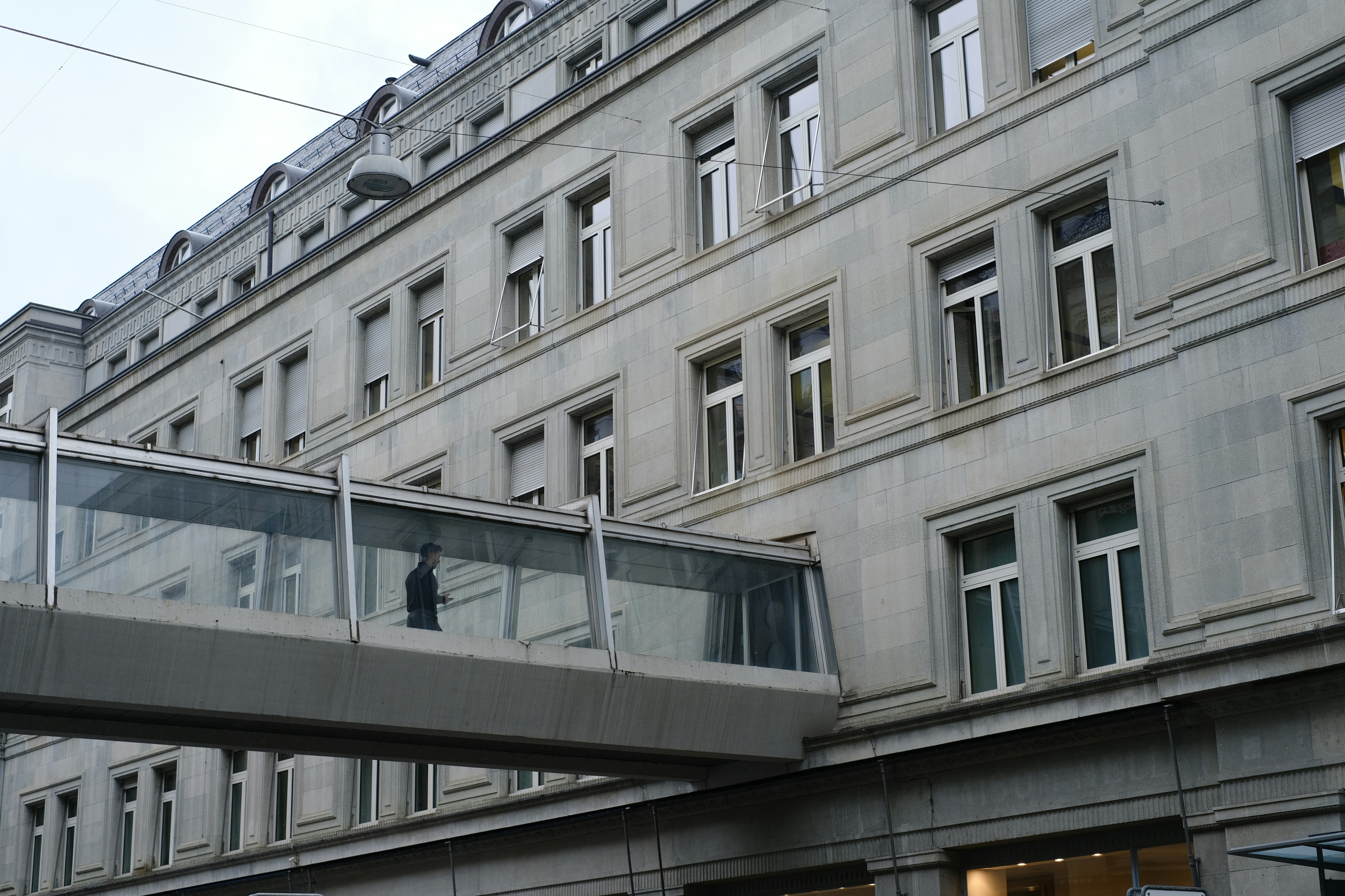 a person walking across a bridge in front of a building