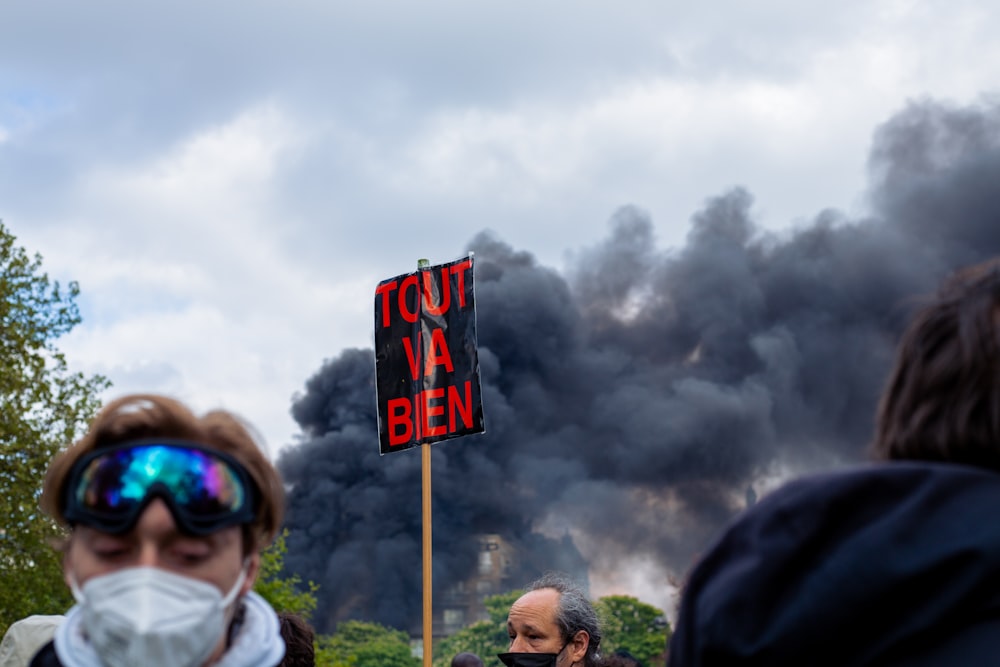 a group of people standing in front of a black cloud of smoke