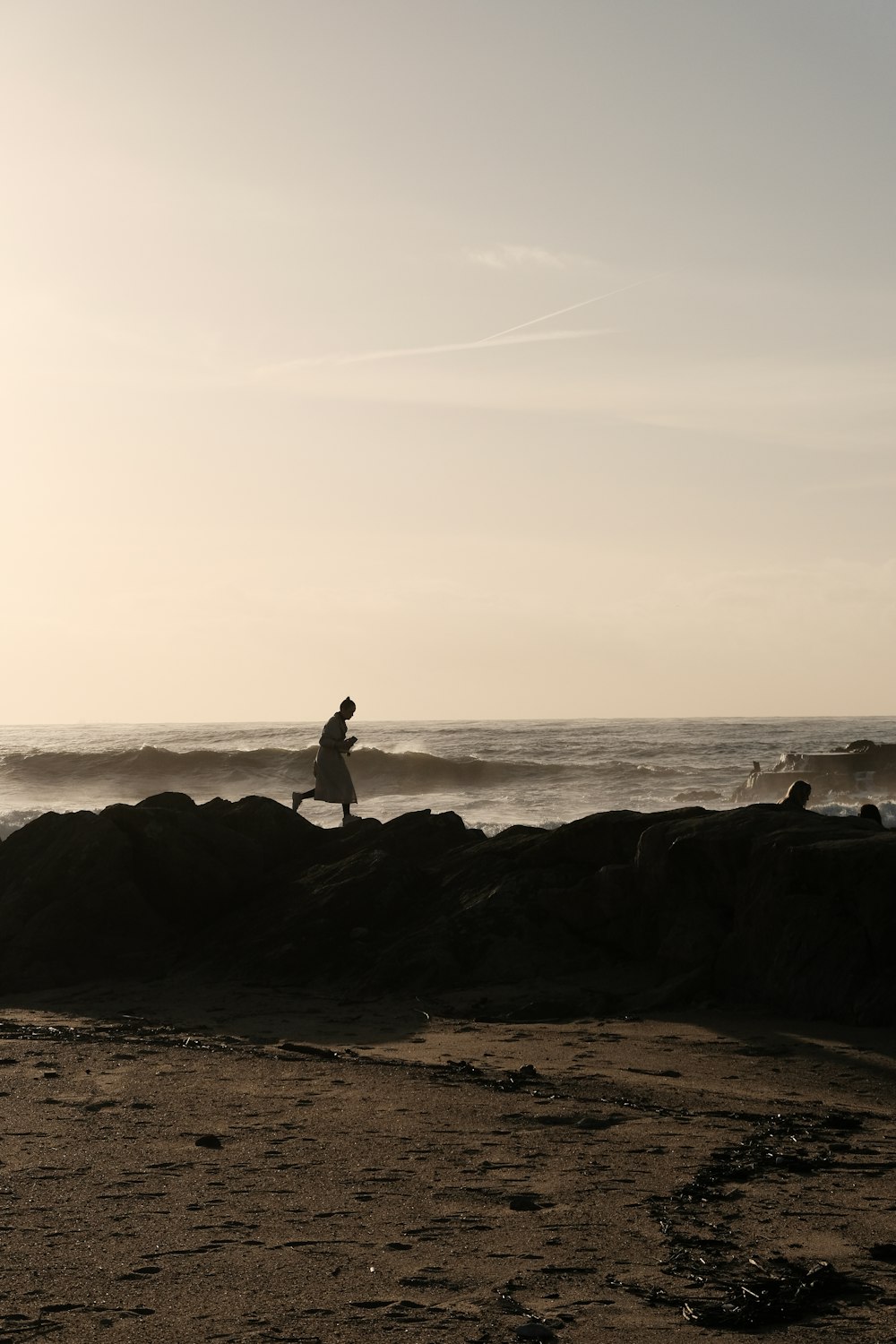 a person running on a beach near the ocean